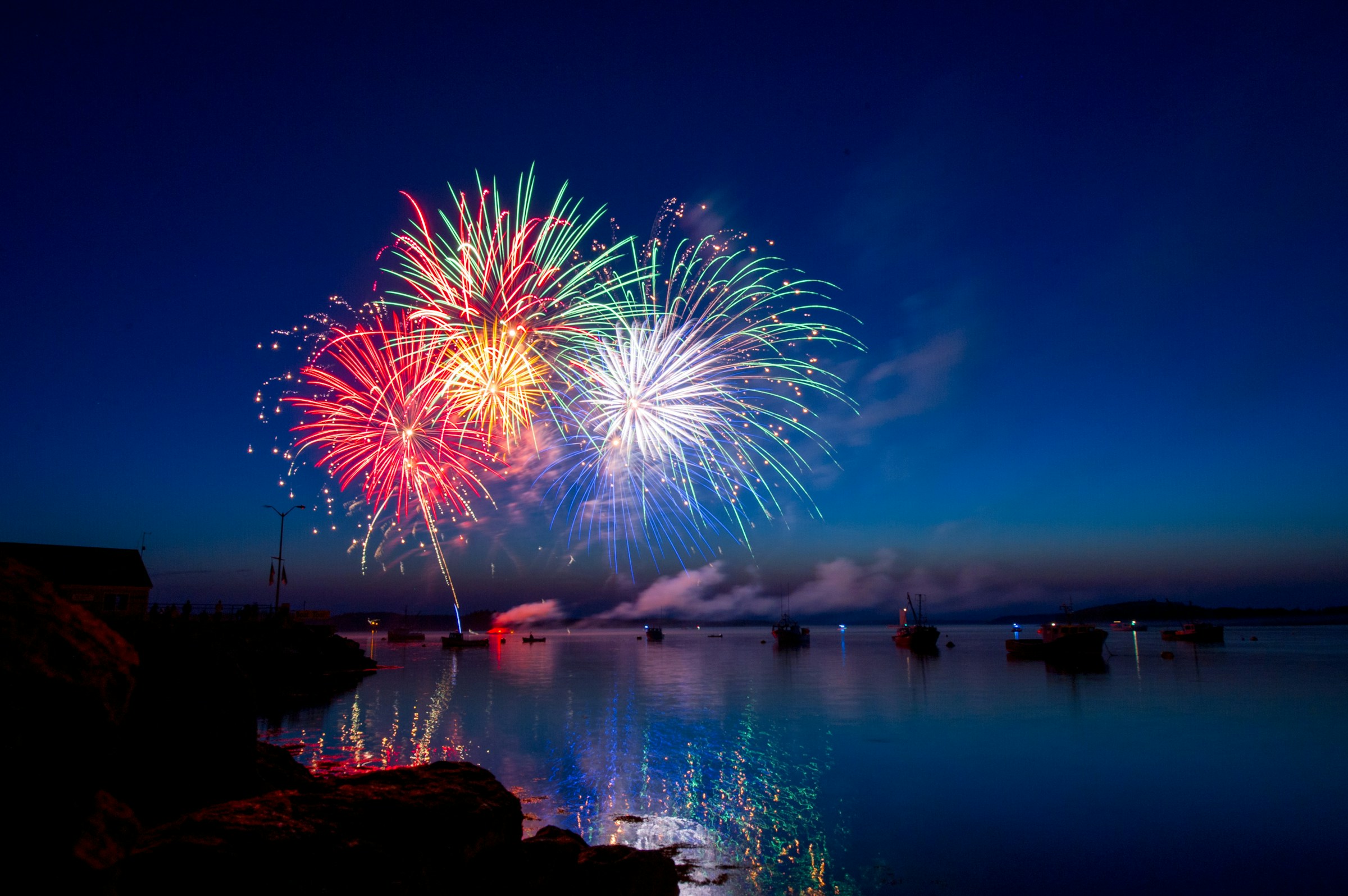 A fireworks show against a deep blue night sky.